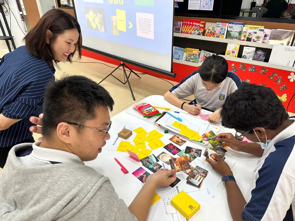 Facilitator guiding students using ideation tools in a design thinking workshop