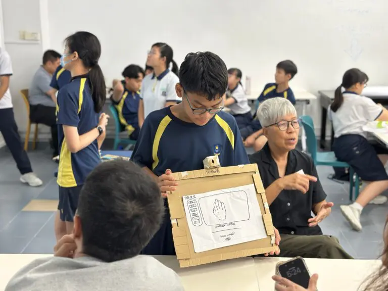 A student with the help of an interpreter presenting a design prototype for the deaf community to a member of the SADeaf community