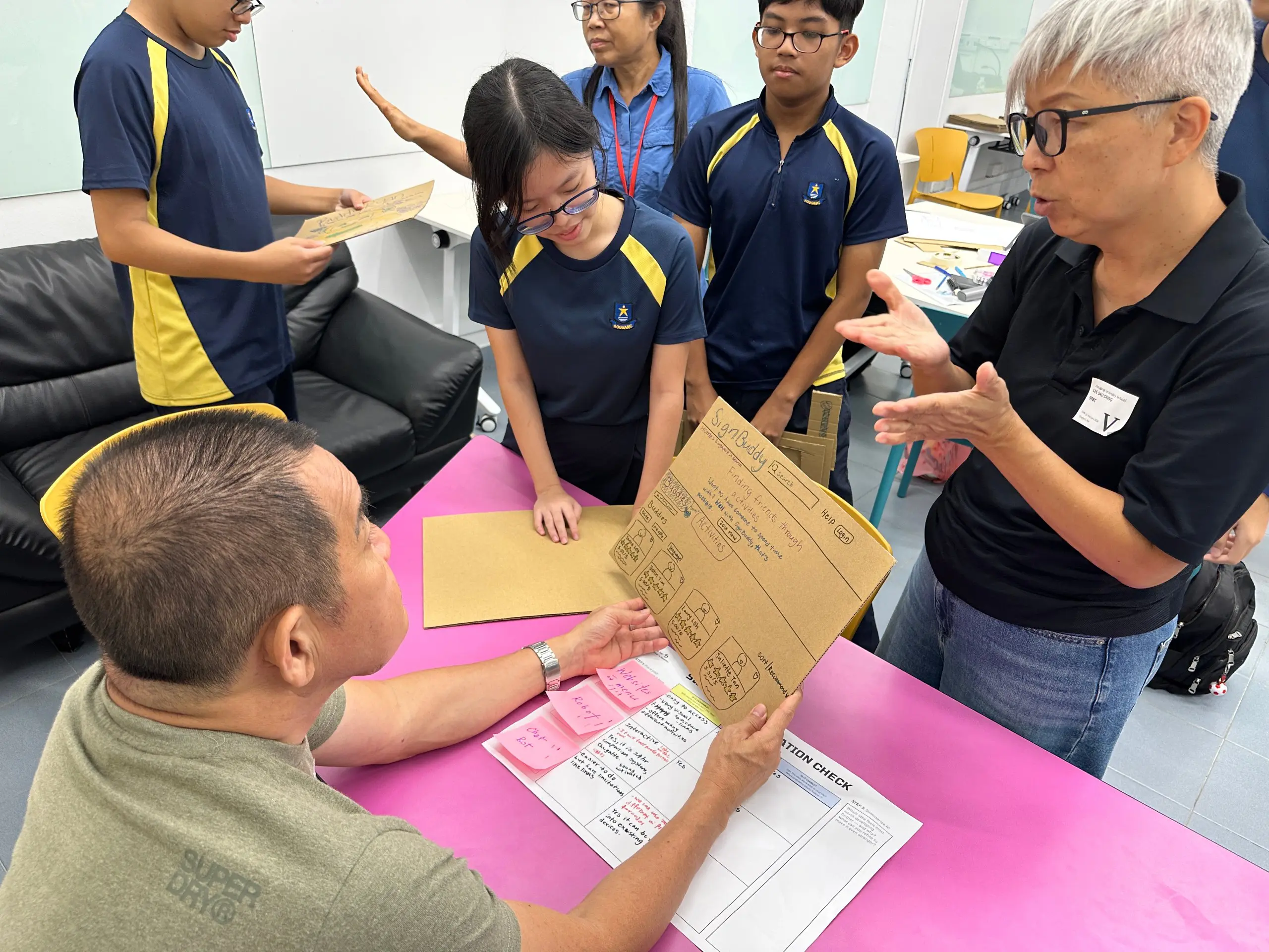 Students working directly with a member of the deaf community to gather feedback and improve their prototype during a VIA design thinking workshop